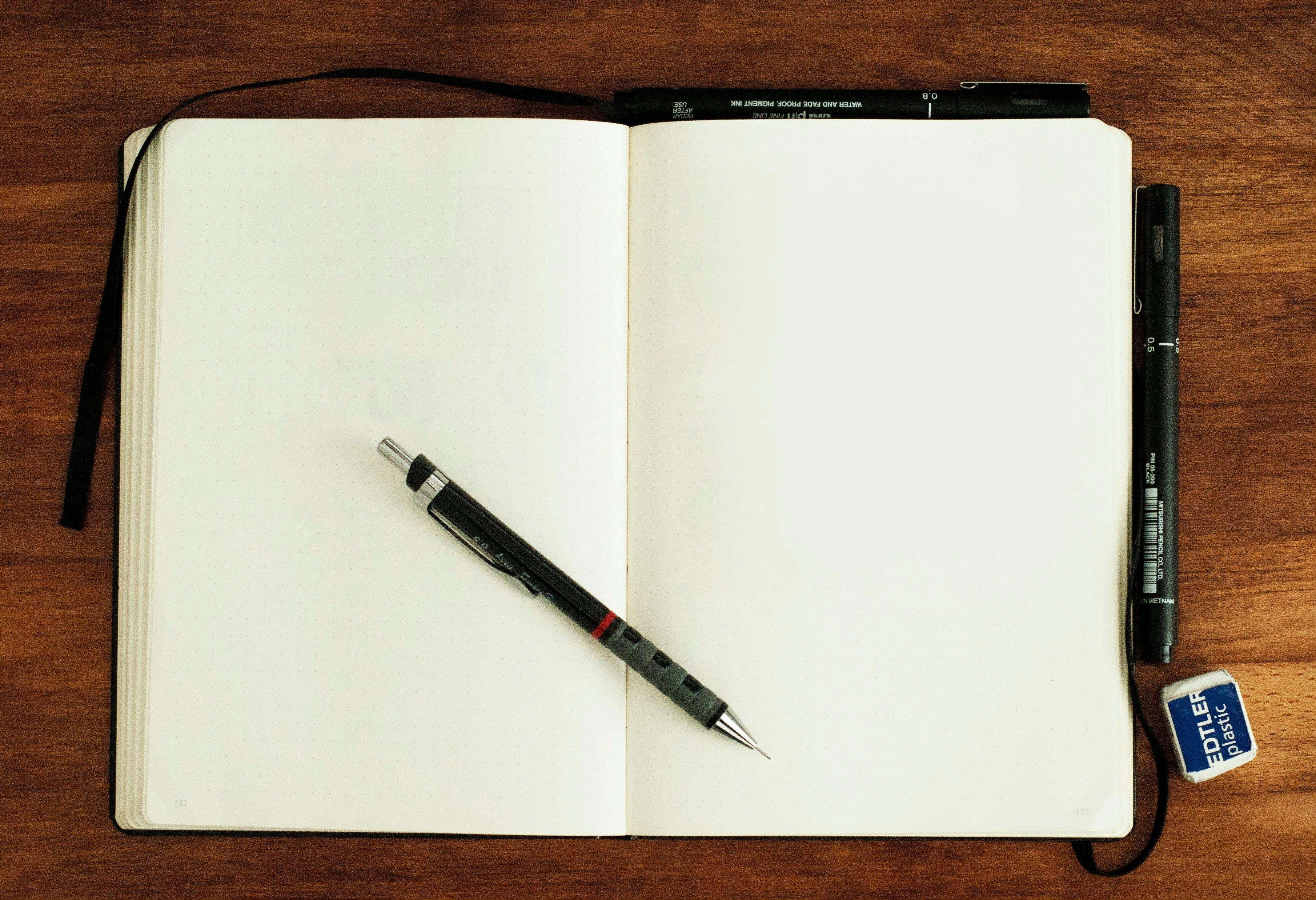 a notebook and pen on a wooden table